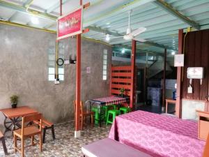 a restaurant with tables and chairs in a room at Lungmin homestay in Mae Hong Son