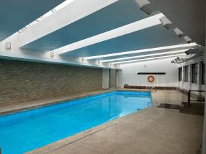 - une piscine d'eau bleue dans un bâtiment dans l'établissement Departamento MBlanc, Ski El Colorado,, Salida a Canchas, Piscina, à Santiago