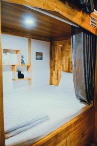 a large bed in a wooden room with at The Dorm Tam Toà in Xóm Ðé