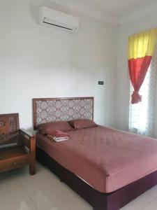 a bedroom with a bed and a table and a window at Teratak Tuan Muda Homestay in Melaka