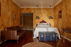 1 dormitorio con 1 cama, 1 silla y 1 maleta en Eltham Hotel NSW, en Eltham