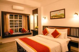 a bedroom with a large bed and a window at Namastay Leisure Homes in Kovalam
