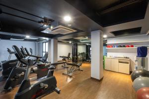 a gym with several treadmills and exercise bikes at The Yama Hotel Phuket - SHA Extra Plus in Kata Beach