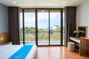 a bedroom with a bed and a large window at Havana Con Dao Hotel in Con Dao