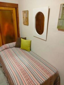 ein Bett mit einem grünen Kissen an der Wand in der Unterkunft Apartamento a pie de playa en San Marcos in San Marcos