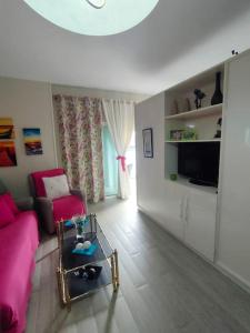 ein Wohnzimmer mit einem rosa Sofa und einem Tisch in der Unterkunft Apartamento a pie de playa en San Marcos in San Marcos