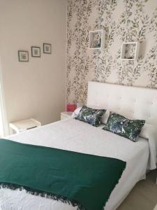 ein Schlafzimmer mit einem großen Bett und einer grünen Decke in der Unterkunft Apartamento a pie de playa en San Marcos in San Marcos