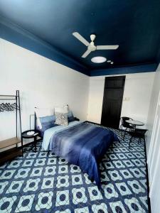 een slaapkamer met een bed en een plafondventilator bij Wanna Stay? in Cairns