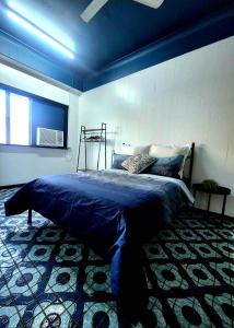 a bedroom with a bed with a blue comforter at Wanna Stay? in Cairns
