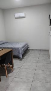 1 dormitorio con cama, escritorio y mesa en Canoas Hotel, en Três Lagoas