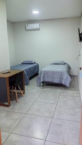 Habitación con 2 camas, escritorio y mesa. en Canoas Hotel, en Três Lagoas