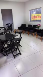 una habitación con mesas y sillas y un cartel en Canoas Hotel, en Três Lagoas