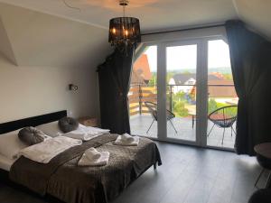 a bedroom with a bed and a large sliding glass door at Apartamenty Antonio 2 in Kudowa-Zdrój