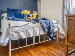 uma cama com um cobertor azul e branco em Moss Cottage em Burry Port