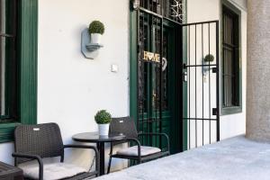patio z 2 krzesłami, stołem i drzwiami w obiekcie Home City Center Terrace Apartment w Budapeszcie