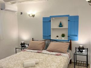 a bedroom with a blue headboard and a bed at Greek House Tatiana in Kos