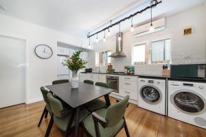 a kitchen with a table and chairs in a room at Opposite Park - Nearby Beach in Melbourne