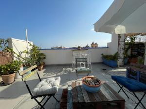 a patio with a table and chairs on a roof at Charming home with private terrace,heart of Málaga in Málaga