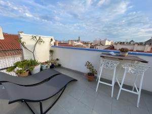 a balcony with a table and chairs on a roof at Charming home with private terrace,heart of Málaga in Málaga