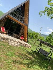 a building with two chairs and a table in front of it at Hillside Borjomi in Borjomi