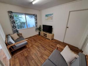 a living room with a couch and a television at Castaways Moreton Island in Bulwer