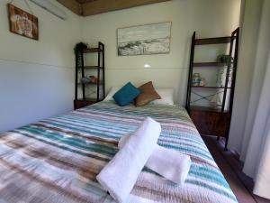 een slaapkamer met een bed met handdoeken erop bij Castaways Moreton Island in Bulwer