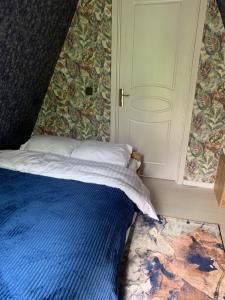 a bedroom with a blue bed and a door at Hillside Borjomi in Borjomi