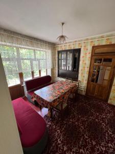 a living room with a table and a couch at Lovely home in Osh