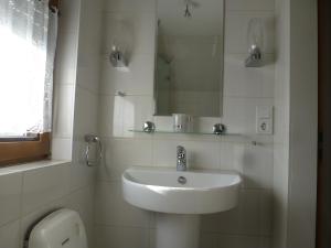 Un baño blanco con lavabo y espejo. en Ferienwohnungen Eckstein, en Bernkastel-Kues 20 fotos más