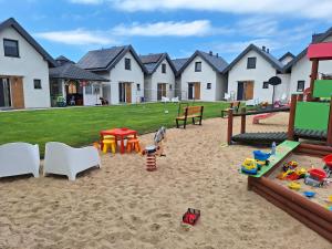 a playground with play equipment in the sand at Domki Na Dobrym Kursie in Jastrzębia Góra