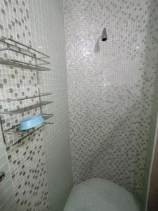 La salle de bains est pourvue d'une douche avec du carrelage blanc. dans l'établissement Seaview Apartment Amanzimtoti, à Amanzimtoti