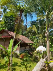a house in the middle of a garden with palm trees at Kebun Villa, Belimbing, Bali in Tabanan