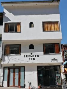 a white building with the sign for premier inn at Hostal Premier Inn in Machu Picchu