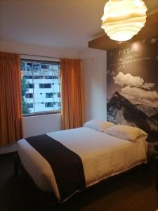 1 dormitorio con cama grande y ventana grande en Hostal Premier Inn, en Machu Picchu