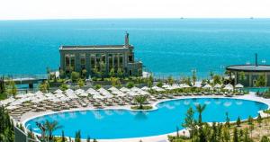 - une vue sur un complexe avec une piscine et des parasols dans l'établissement Апартаменты у моря - в "Green City RESORT", à Baku