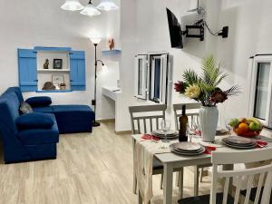 ein Wohnzimmer mit einem Tisch und einem blauen Sofa in der Unterkunft Greek House Tatiana in Kos-Stadt