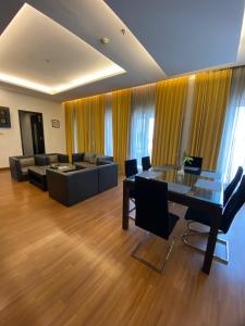 uma sala de estar com uma mesa de vidro e um sofá em Golden Flower by KAGUM Hotels em Bandung