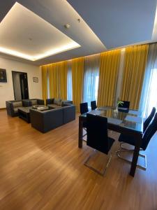Golden Flower by KAGUM Hotels في باندونغ: غرفة معيشة مع طاولة زجاجية وأريكة