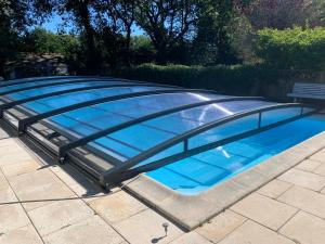 a large swimming pool with a bench around it at La Gentilhommière in Tréffiagat