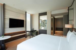 Habitación de hotel con cama y TV de pantalla plana. en dusitD2 Samyan Bangkok, en Bangkok