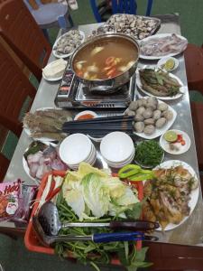 a table with a bunch of food on it at PHÚC AN HOSTEL in Cat Ba