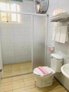 a bathroom with a shower and a toilet and a sink at 好金門民宿 in Jincheng