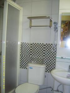 a white bathroom with a toilet and a sink at 好金門民宿 in Jincheng