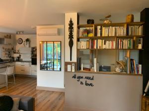 cocina y sala de estar con estante de libros en Jolie maison Borgo trois chambres trois salles de bain en Borgo