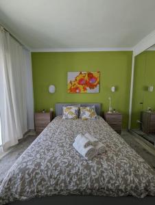een slaapkamer met een groot bed met groene muren bij Apartamento los Cocoteros in Santa Fe de los Boliches