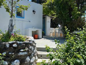 una casa blanca con una mesa y sillas frente a ella en Greek House Tatiana, en Cos