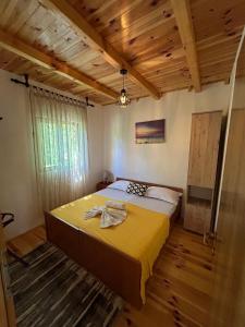 Un dormitorio con una cama grande en una habitación con techos de madera. en Cottage Ajna - Ada Bojana, en Ulcinj