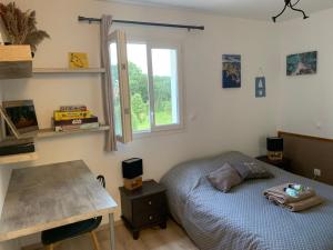 a bedroom with a bed and a desk and a window at Jolie maison Borgo trois chambres trois salles de bain in Borgo