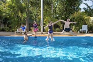 a group of children playing in a swimming pool at Discovery Parks - Darwin in Darwin