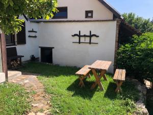 una mesa de picnic y bancos frente a una casa en Anna Porta, en Kan